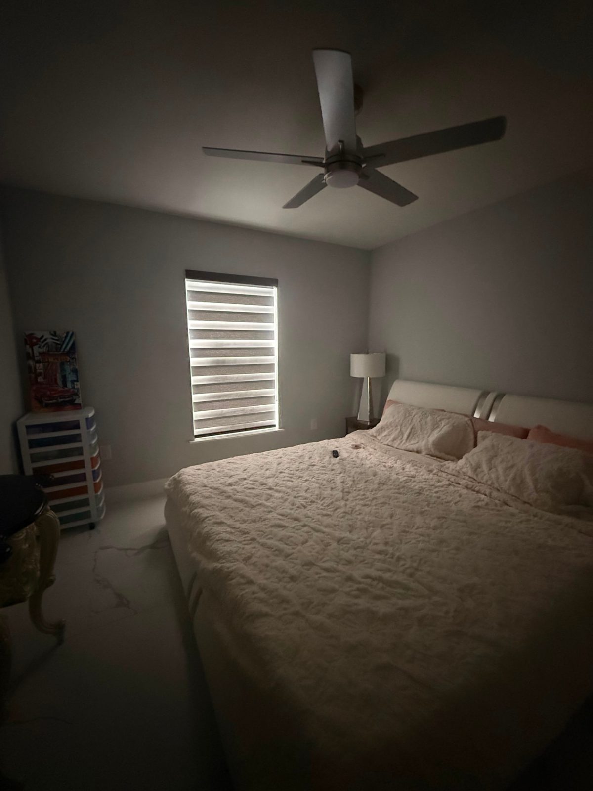 Zebra blind closed for privacy in a bedroom at dusk, light bands still glowing softly